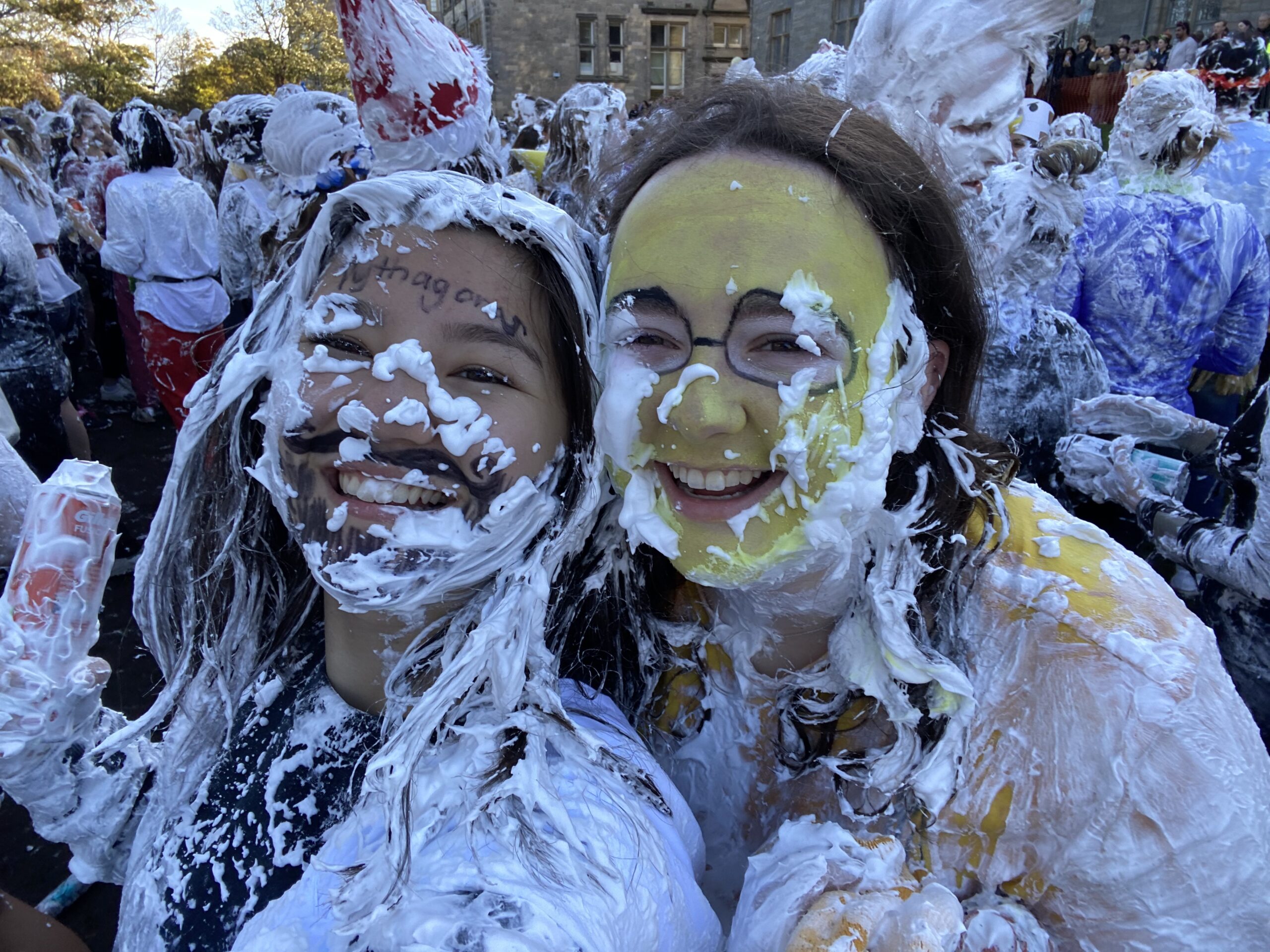 two girls covered in shaving cream dressed in costumes