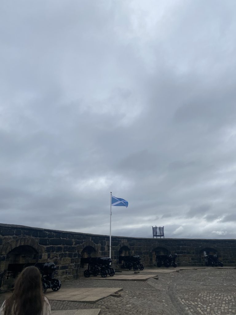 scottish flag waving above canons